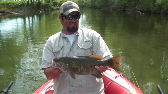 Josh Pfeiffer holding a 4 pound smallmouth bass caught in Little River.